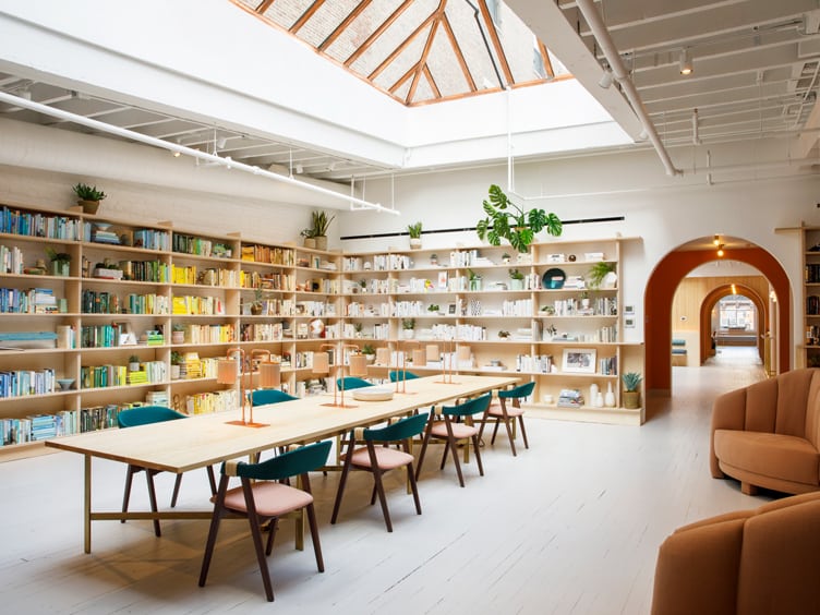 Chiara deRege coworking space color coordinated bookshelves wood industrial desk ceiling 