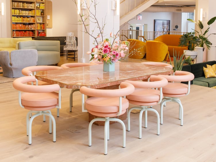 Co-working space pink armchairs around a marble table with floral centerpiece Chiara deRege design