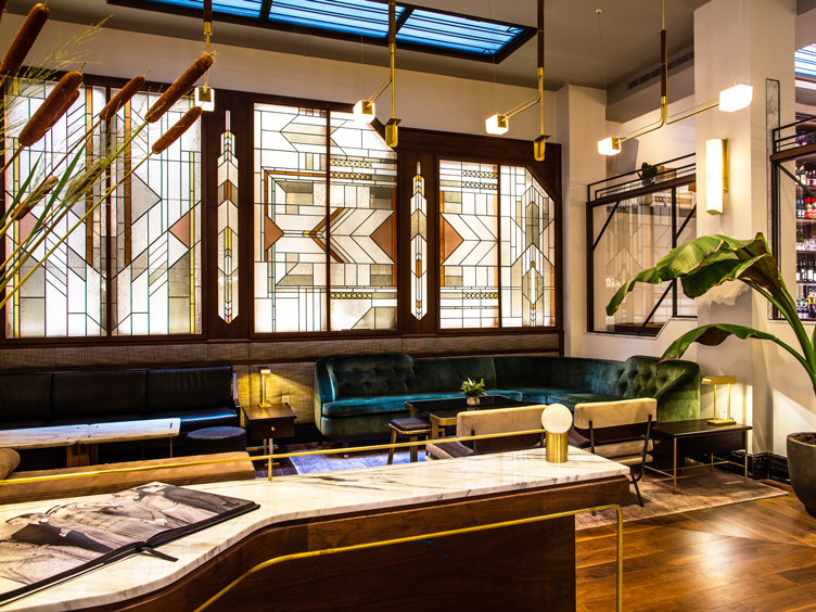 Bar area with deco stained glass, velvet seating and marble topped bar.