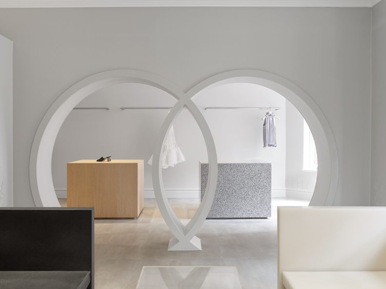 Minimalist closet with white walls and round archways by Fran Hickman 