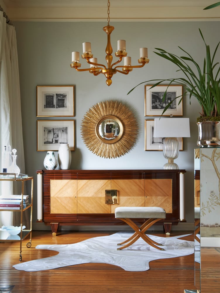 Deco-style credenza with gold burst mirror and cowhide rug