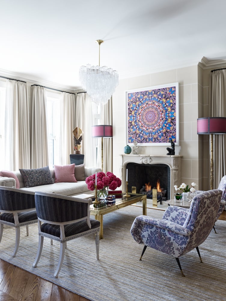Living room with purple accent chairs, crystal chandelier, and graphic painting