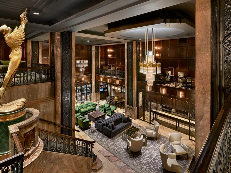 Lobby with dark brown marble, gold chandeliers, and dark brown wood accents throughout.